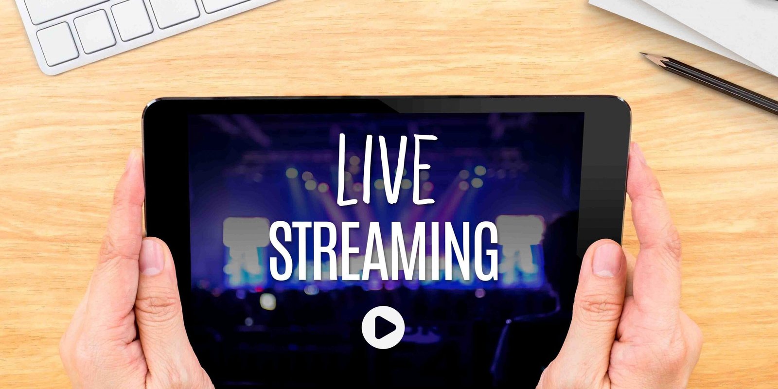 Hand holding tablet with Live Streaming word on wood table ,Inte