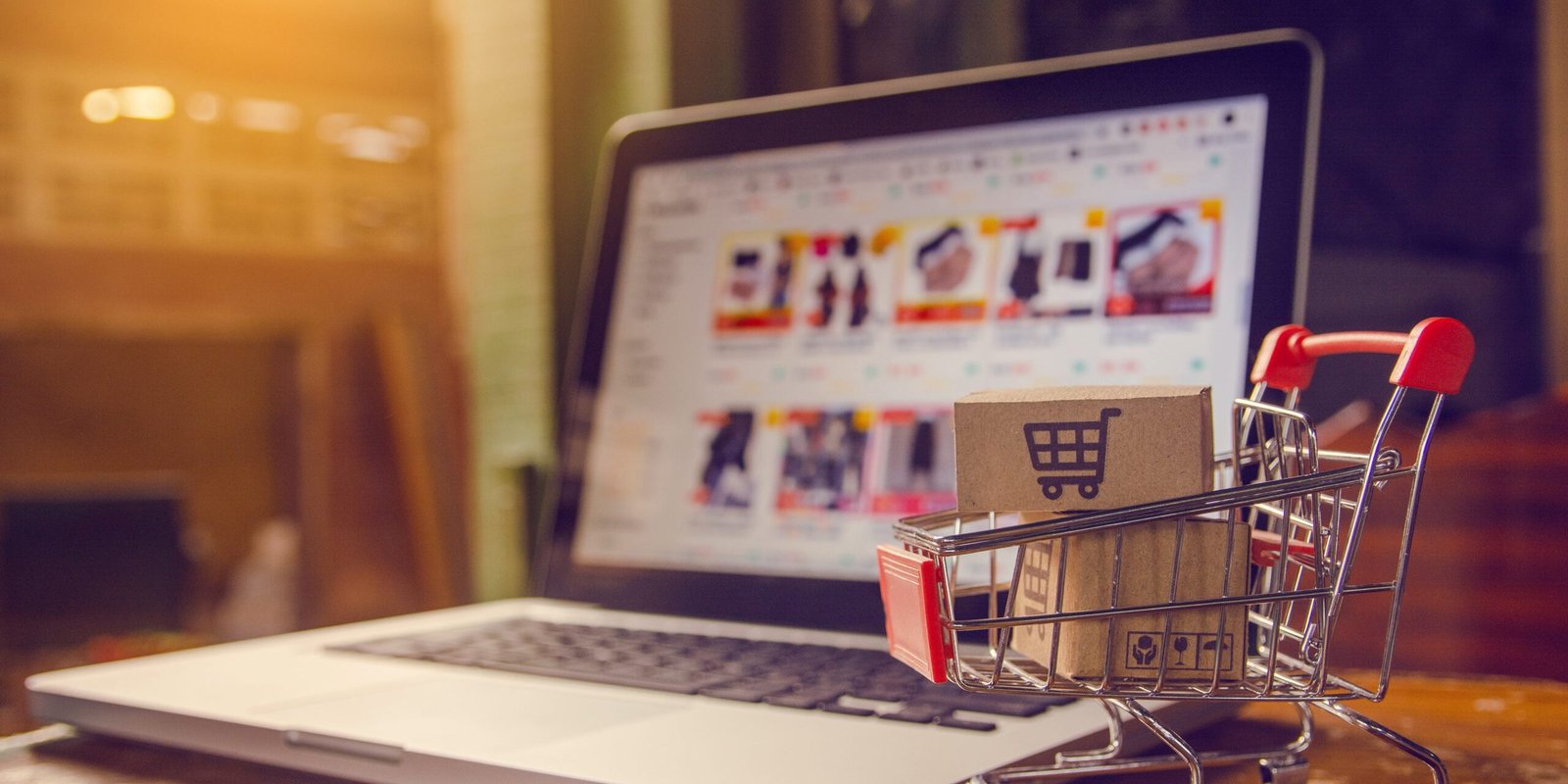 Shopping online. Parcel or cardboard boxes with a shopping cart logo in a trolley on a laptop keyboard. Shopping service on The online web. offers home delivery.